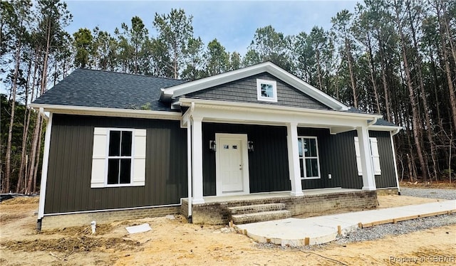 view of front of house with covered porch and roof with shingles