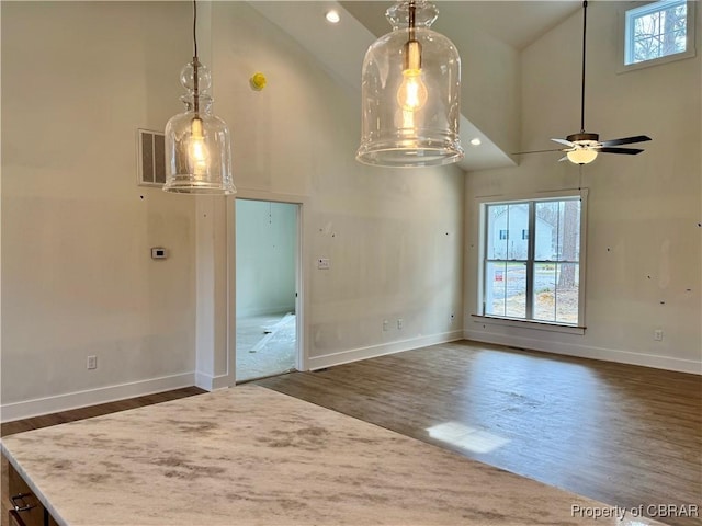 interior space with visible vents, baseboards, high vaulted ceiling, and dark wood-style floors