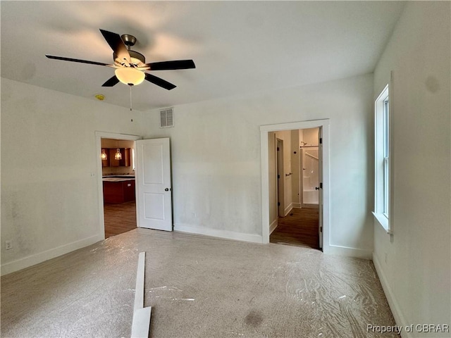 unfurnished bedroom with baseboards, visible vents, and ensuite bathroom