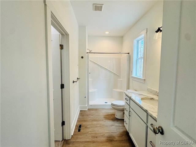 full bath with visible vents, toilet, a stall shower, wood finished floors, and vanity