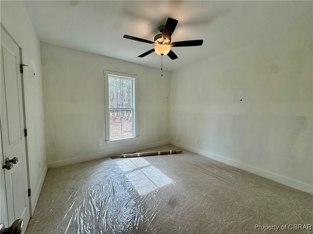 spare room with a ceiling fan and baseboards