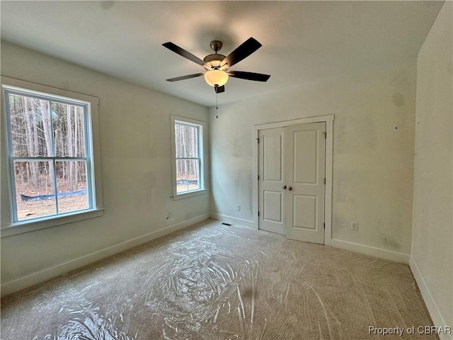 unfurnished bedroom featuring a closet, a ceiling fan, and baseboards