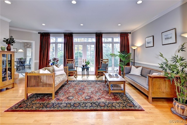 living room with light wood-type flooring, ornamental molding, and french doors