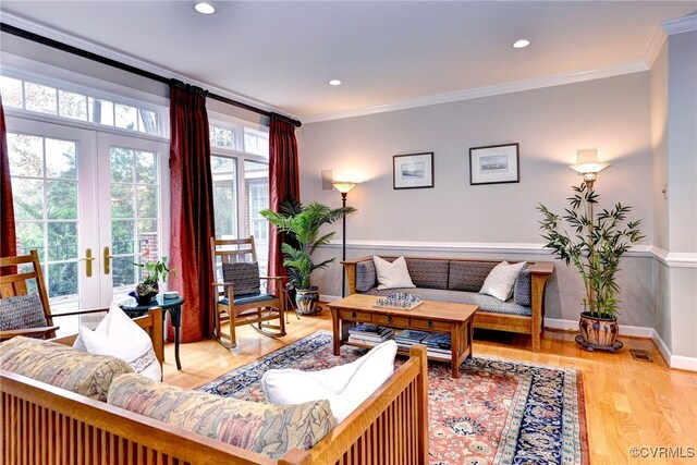 living room featuring hardwood / wood-style flooring, ornamental molding, and french doors