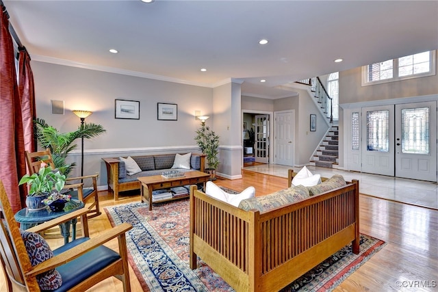 living room with crown molding and light hardwood / wood-style flooring