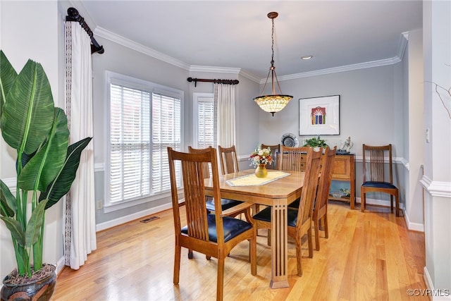 dining area featuring crown molding and light hardwood / wood-style floors