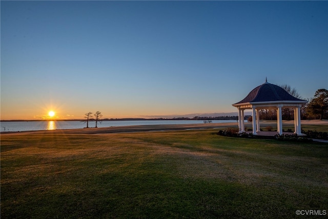 yard at dusk featuring a gazebo and a water view