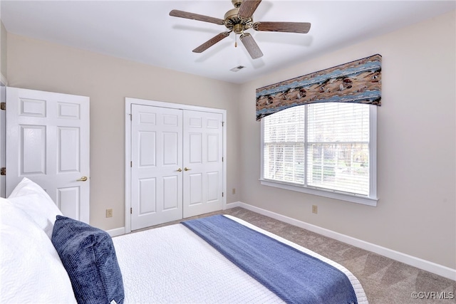 carpeted bedroom featuring ceiling fan and a closet