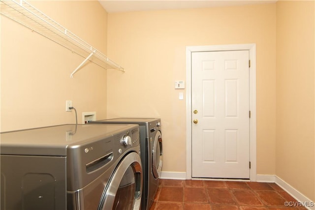 washroom with washing machine and dryer and dark tile patterned floors