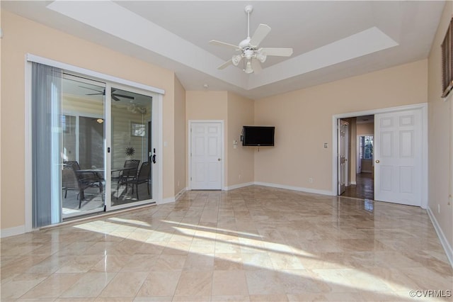 unfurnished room featuring a raised ceiling and ceiling fan