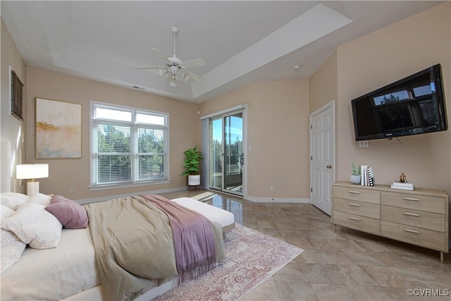 tiled bedroom featuring a raised ceiling, access to exterior, and ceiling fan