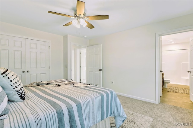 carpeted bedroom with a closet, ensuite bath, and ceiling fan