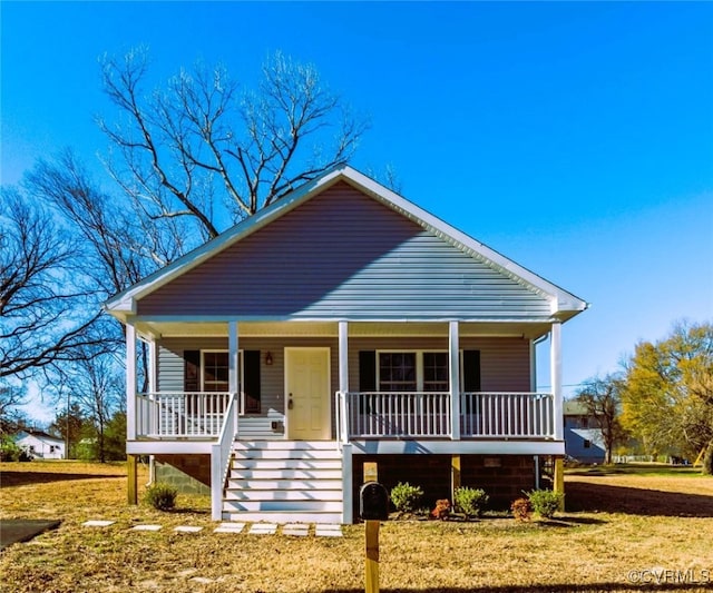 bungalow-style house featuring covered porch and a front lawn