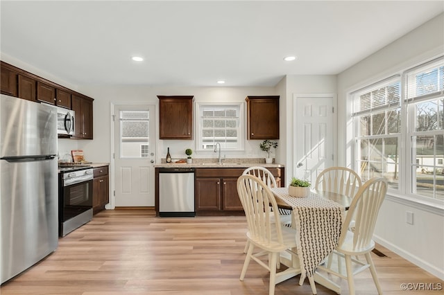 kitchen featuring plenty of natural light, light wood-type flooring, and stainless steel appliances