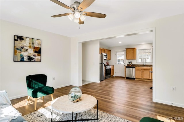 living room with hardwood / wood-style flooring, ceiling fan, and sink