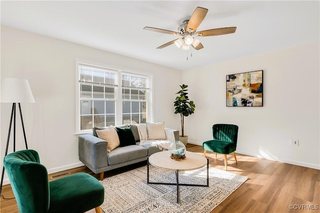 living room with wood-type flooring and ceiling fan