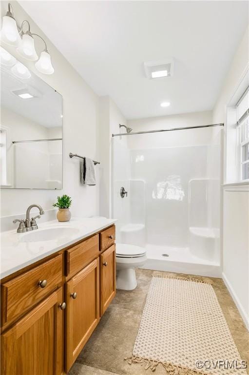 bathroom featuring a shower, vanity, and toilet