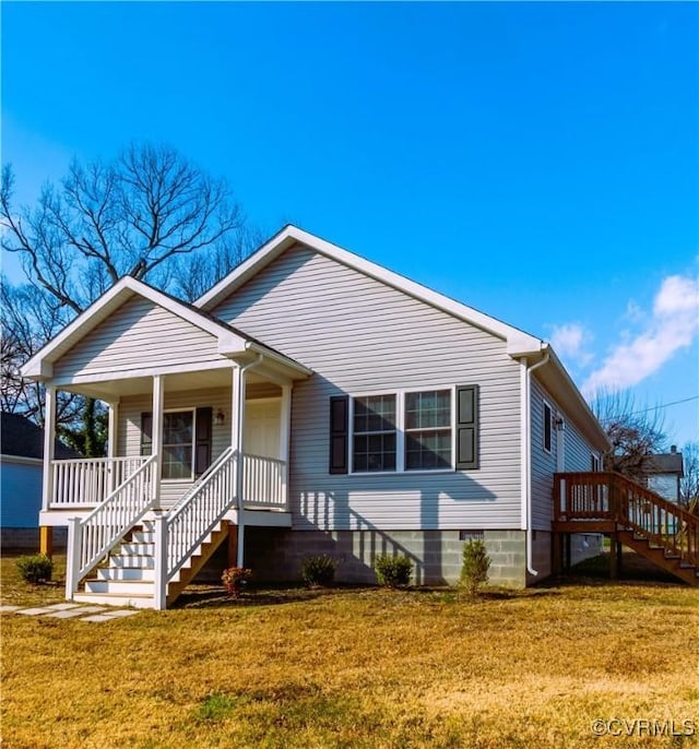 bungalow featuring covered porch and a front yard