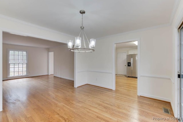 unfurnished dining area with ornamental molding, a chandelier, and light wood-type flooring