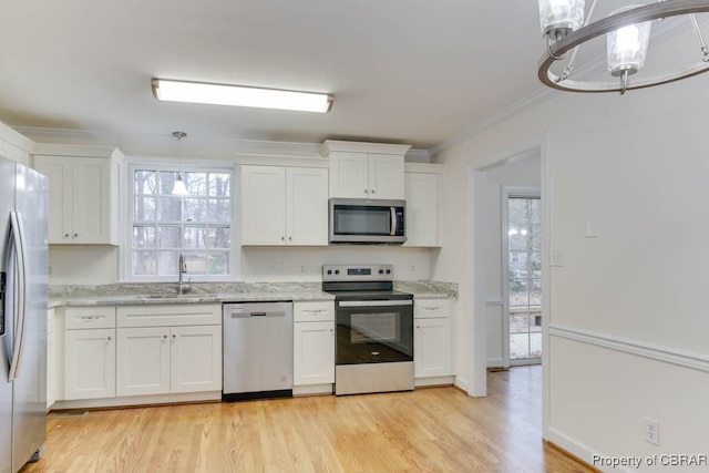 kitchen featuring white cabinetry, ornamental molding, stainless steel appliances, and sink