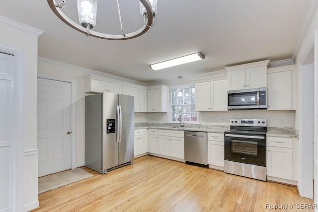 kitchen featuring sink, white cabinets, ornamental molding, stainless steel appliances, and light wood-type flooring