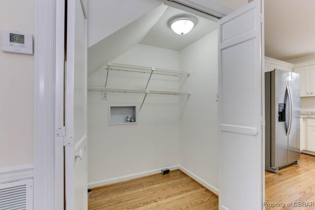 clothes washing area featuring hookup for a washing machine and light wood-type flooring