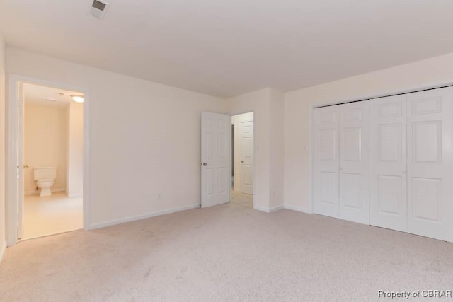 unfurnished bedroom featuring a closet and light carpet