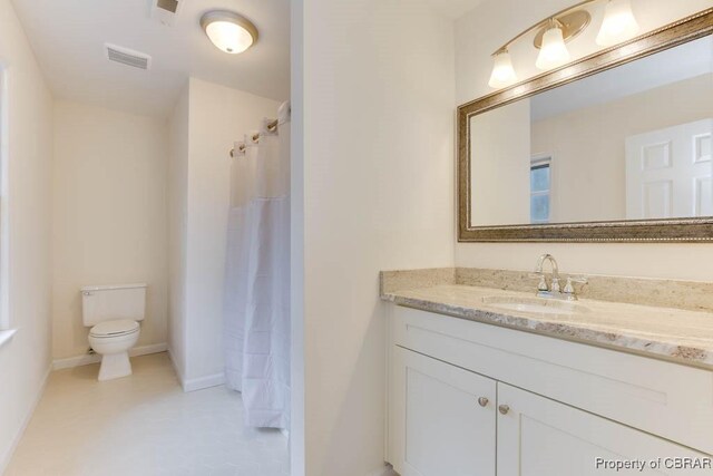 bathroom featuring walk in shower, vanity, and toilet