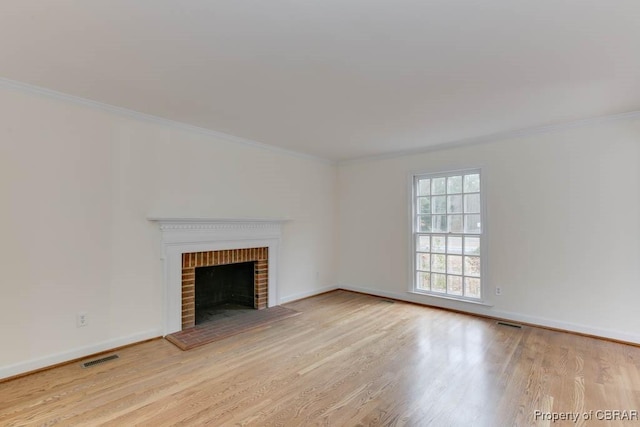 unfurnished living room with ornamental molding, a fireplace, and light hardwood / wood-style floors