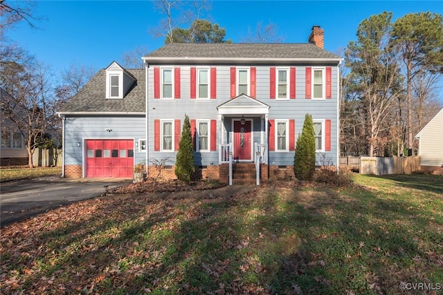 colonial home with a front lawn and a garage