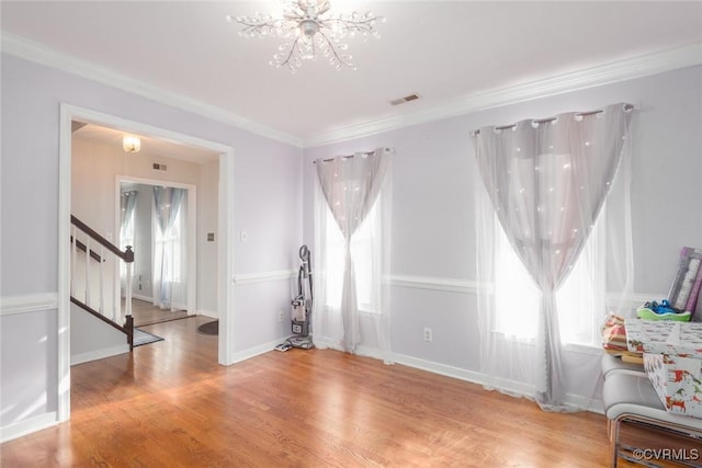 unfurnished room with crown molding, hardwood / wood-style floors, and a notable chandelier