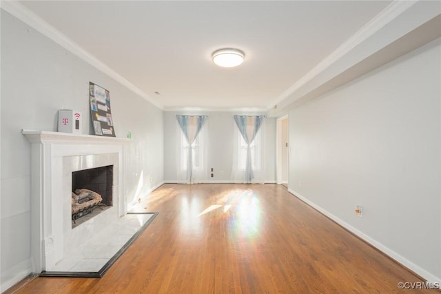 unfurnished living room featuring a fireplace, wood-type flooring, and crown molding