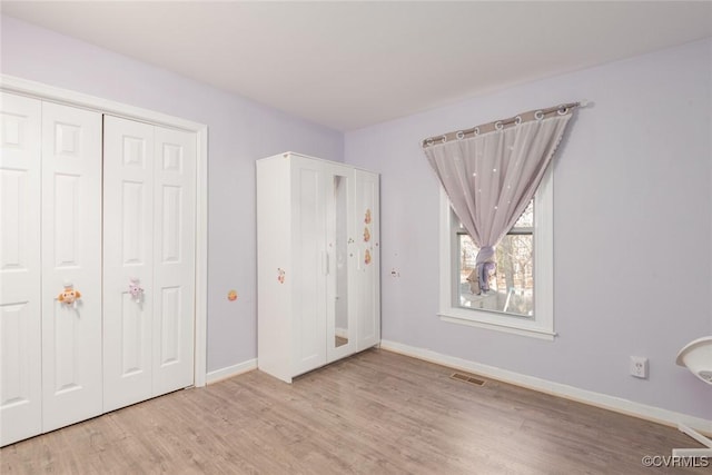 unfurnished bedroom featuring a closet and light wood-type flooring