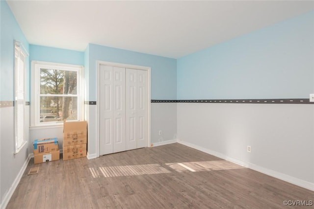 unfurnished bedroom featuring a closet and hardwood / wood-style floors