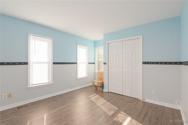 unfurnished bedroom with hardwood / wood-style flooring and a closet