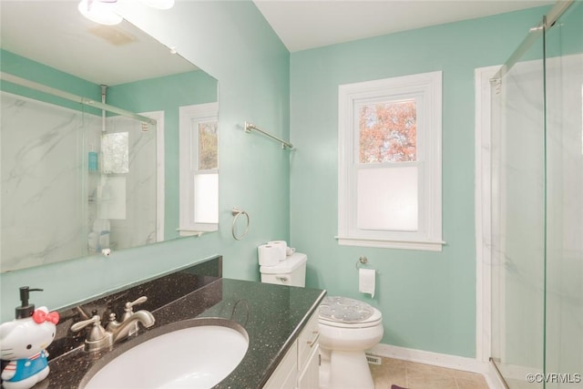 bathroom featuring toilet, vanity, tile patterned floors, and a shower with door