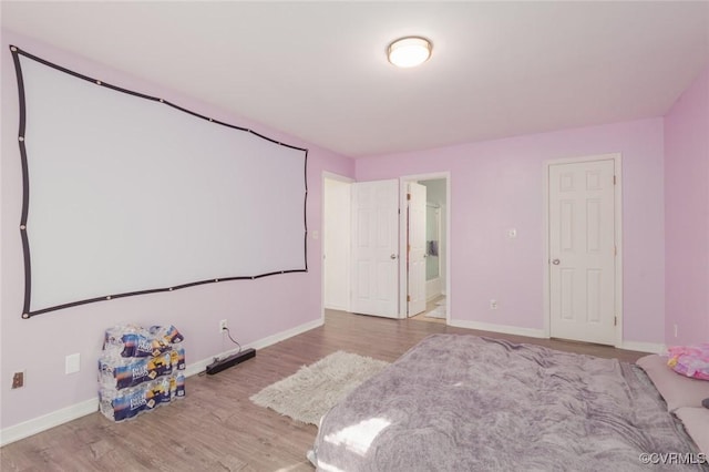 bedroom with ensuite bathroom and light wood-type flooring