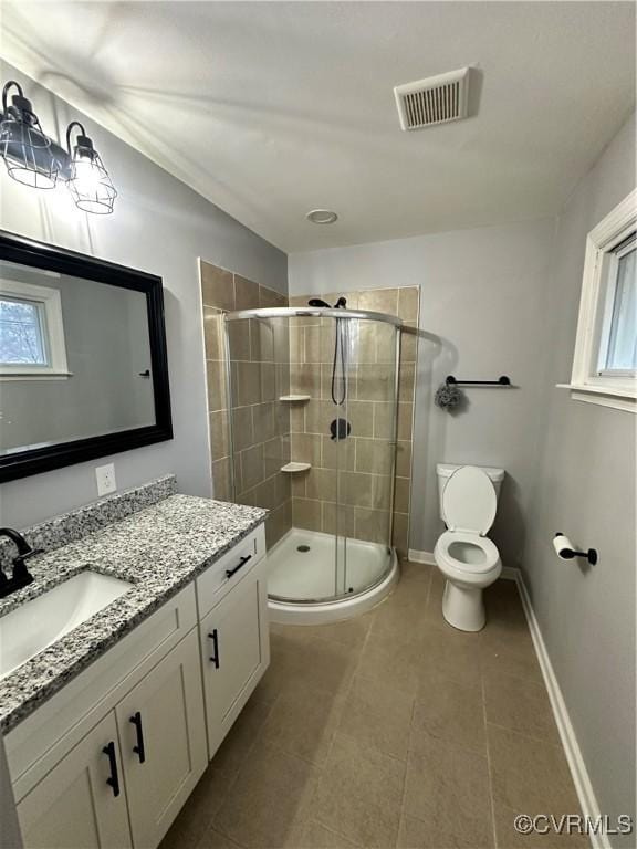 bathroom with vanity, toilet, plenty of natural light, and walk in shower