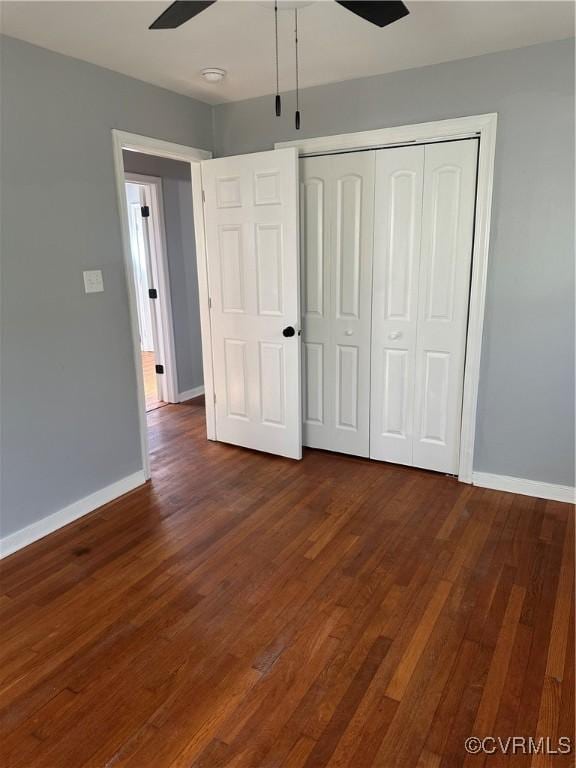 unfurnished bedroom with a closet, dark wood-type flooring, and ceiling fan