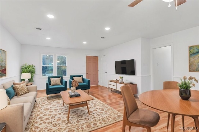 living room with ceiling fan and light wood-type flooring