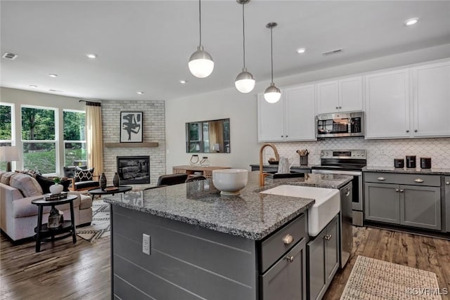 2013 Farmstead Mill Ct, Glen Allen, VA 23059 - kitchen with appliances with stainless steel finishes, gray cabinetry, dark wood-style flooring, open floor plan, and stone counters