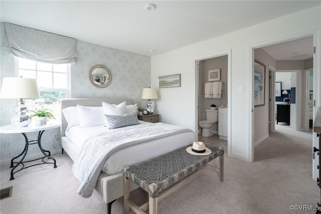 carpeted bedroom featuring ensuite bathroom