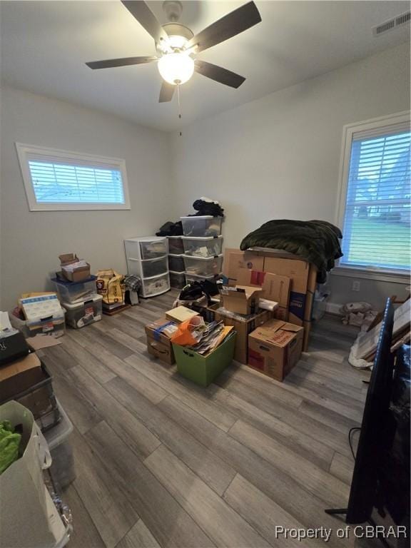 bedroom with a ceiling fan, visible vents, and wood finished floors