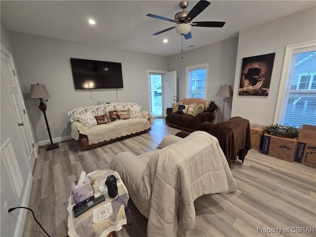 living room featuring light hardwood / wood-style flooring, a wealth of natural light, and ceiling fan