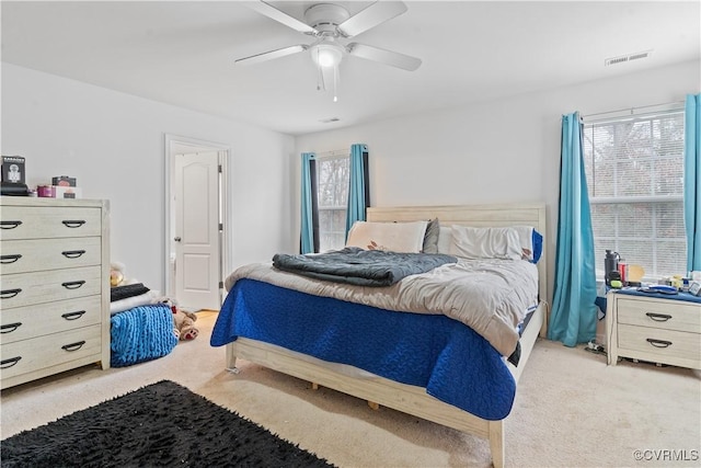 carpeted bedroom with ceiling fan and multiple windows