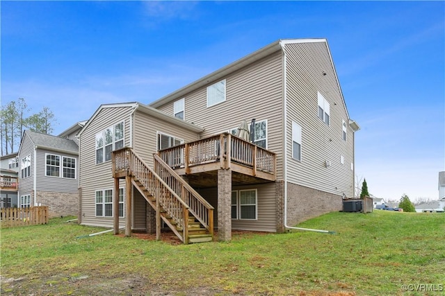 back of house featuring a lawn, a wooden deck, and central AC