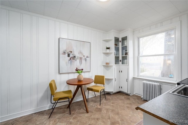 sitting room with radiator heating unit and ornamental molding