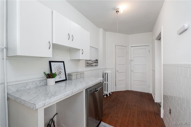 kitchen featuring dishwasher, radiator heating unit, dark hardwood / wood-style flooring, white cabinets, and tile walls