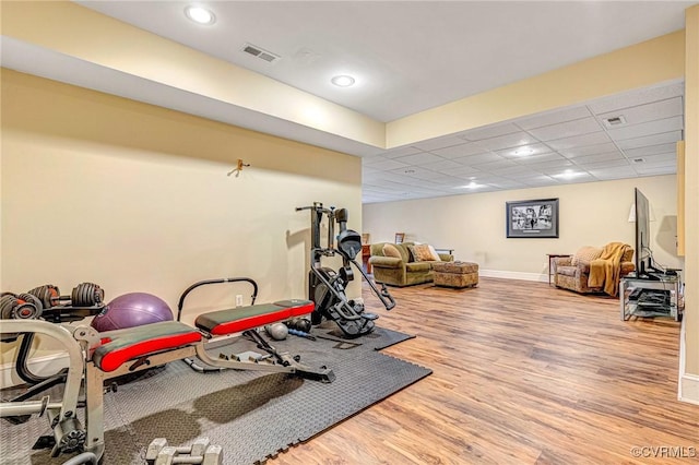 exercise area with a drop ceiling and wood-type flooring