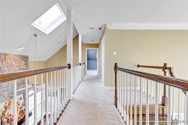 hallway featuring light colored carpet, lofted ceiling with skylight, and crown molding